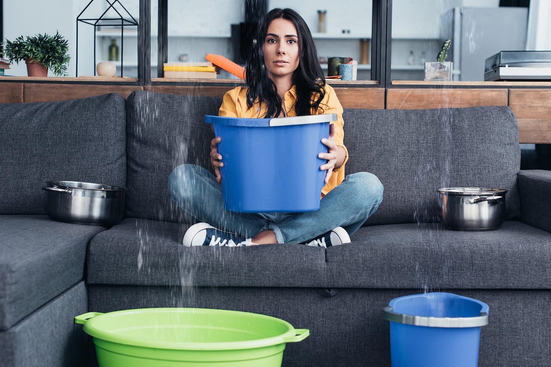 water-damage-aquadry | woman holding a bucket trying to catch water dripping